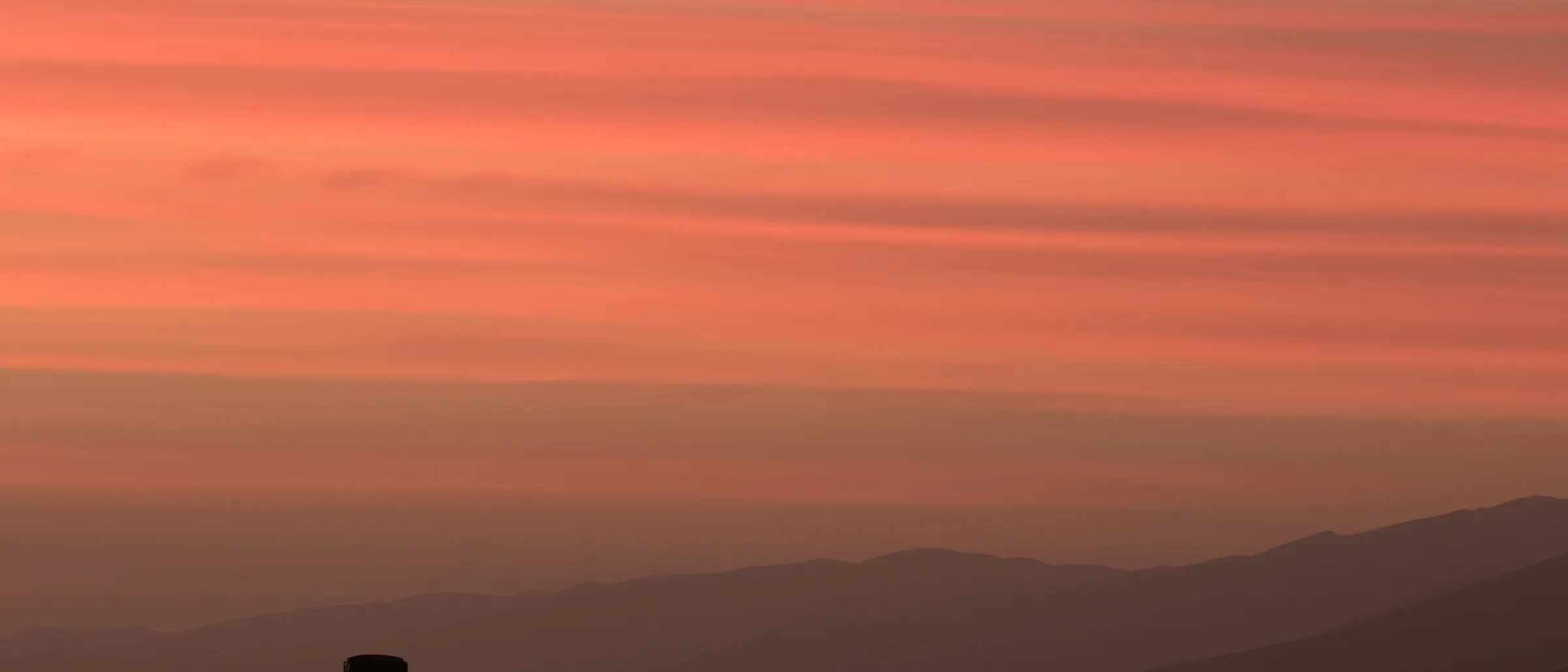 Safarifahrzeug in der Savanne vor dem Abendhimmel